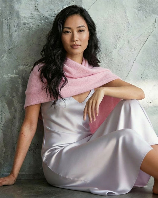 A woman draped in the Alashan Cashmere Topper styled as a breezy travel wrap, showcasing the versatility of the Alashan Cashmere collection