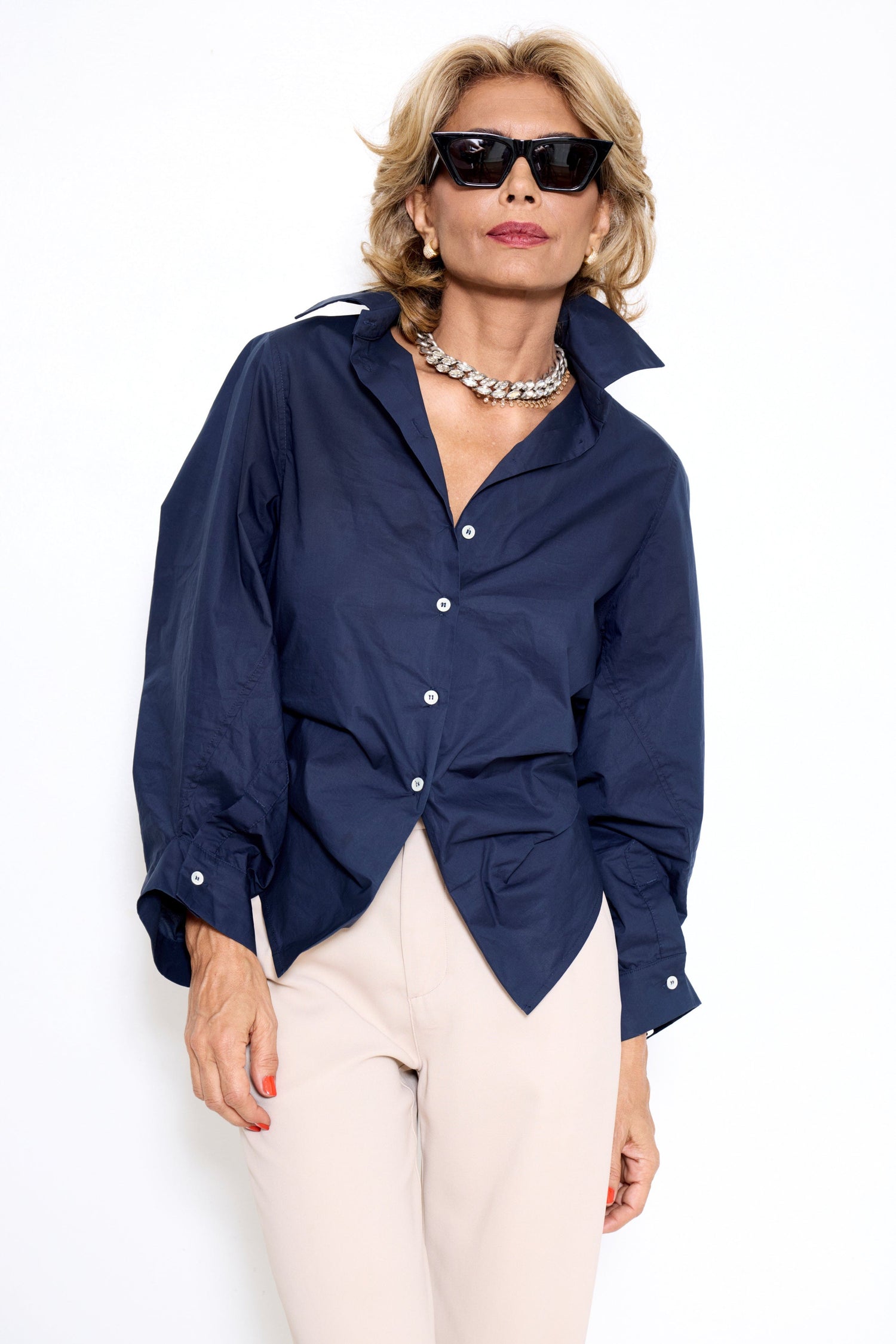 Woman modeling a navy blue A Shirt Thing tailored shirt styled with cream pants