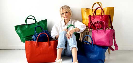 woman with a collection of handbags in many colors 