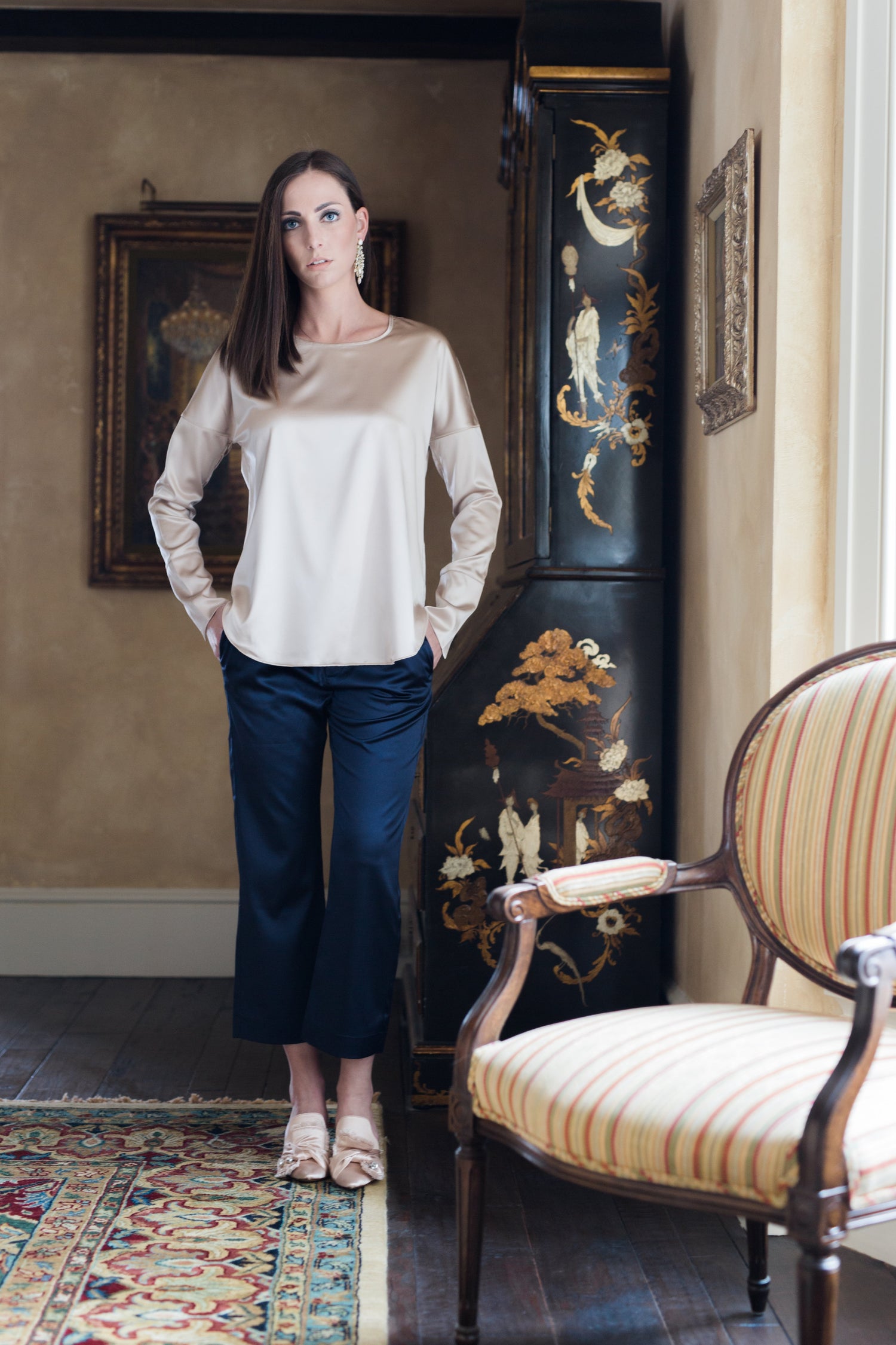 woman wearing a silk champagne colored blouse and navy blue silk pants