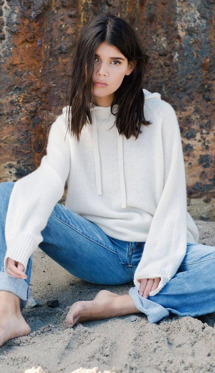 Woman wearing a cashmere hoodie and jeans