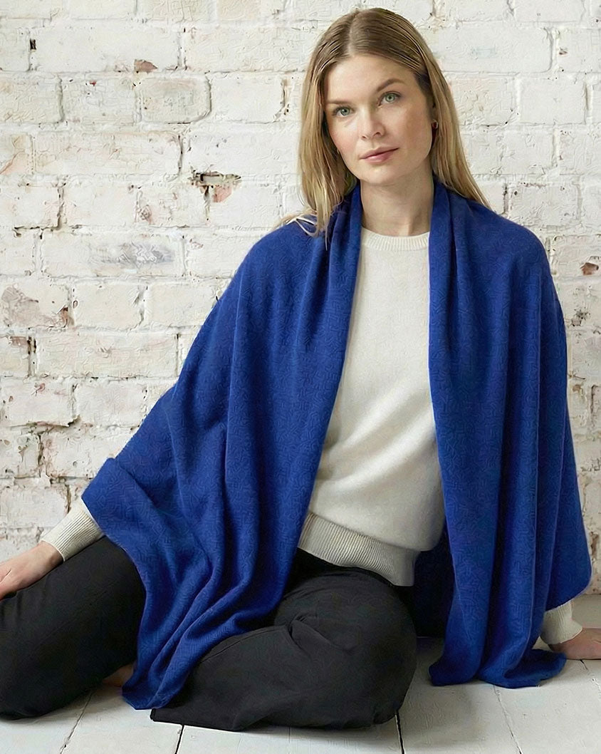 Woman wearing an Alashan cashmere travel wrap layered showcasing women’s luxury cashmere wrap.