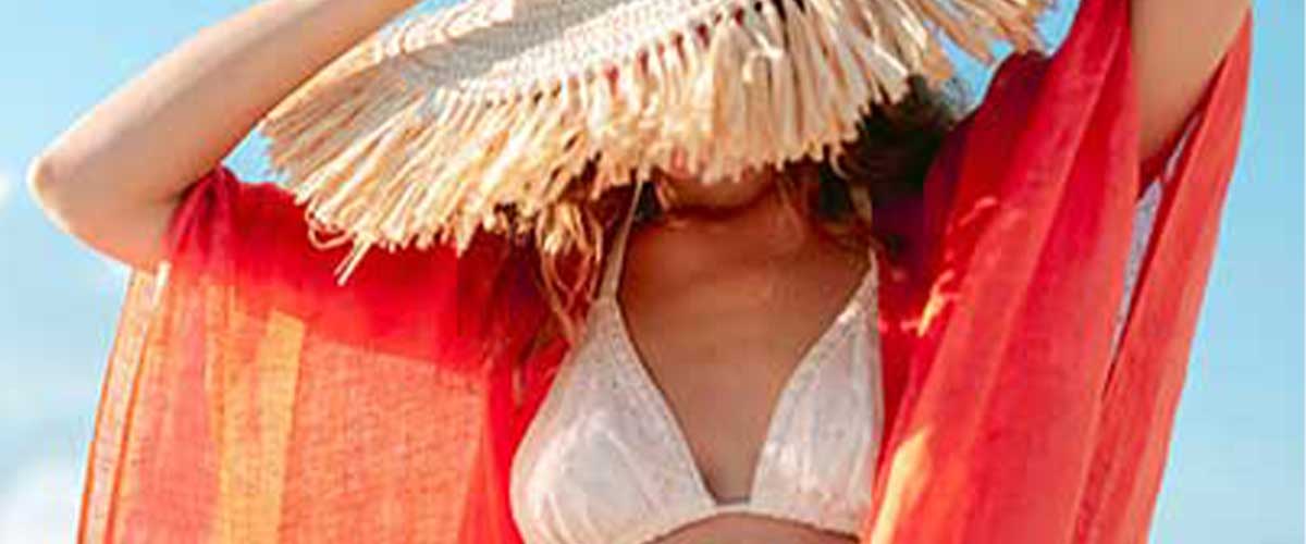 woman wearing a straw hat and orange linen scarf wrap