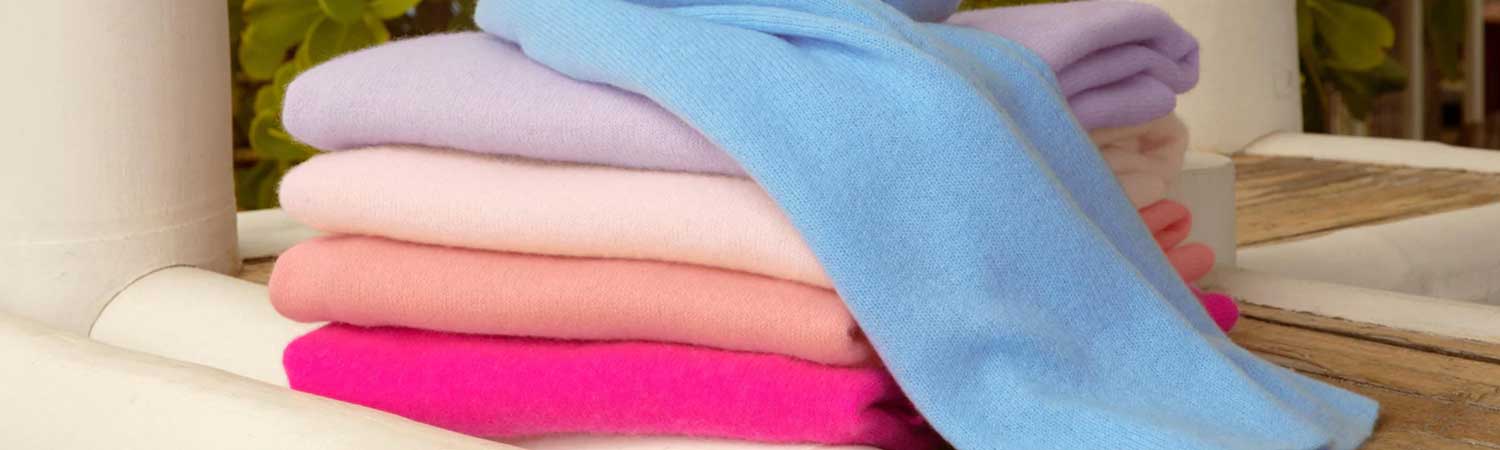 Stacked White + Warren cashmere travel wraps displayed in multiple colors.