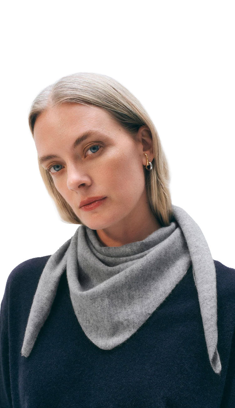 Woman wearing a white and warren cashmere neckerchief mini scarf in heather grey on a white background