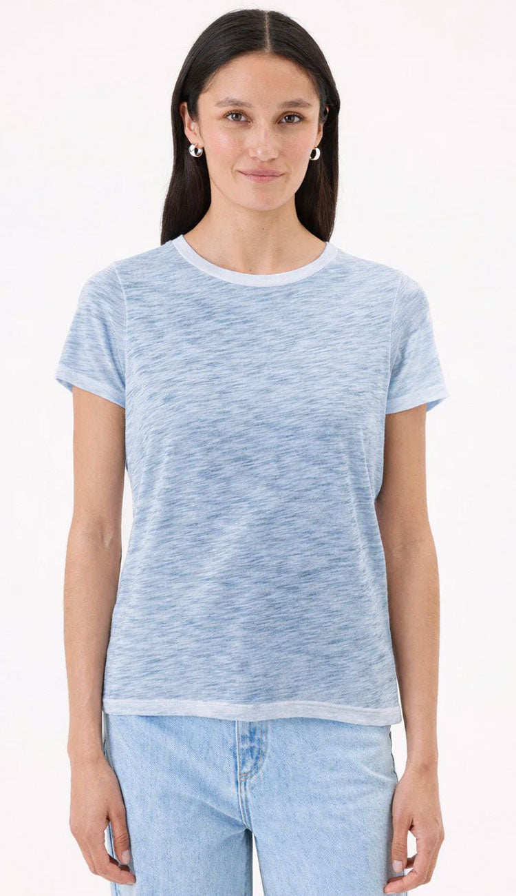 Woman wearing a sea light blue t-shirt by Goldie and jeans on a white background