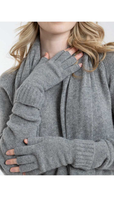 Person wearing a flagstone sweater and matching gloves with a scarf, on a white background