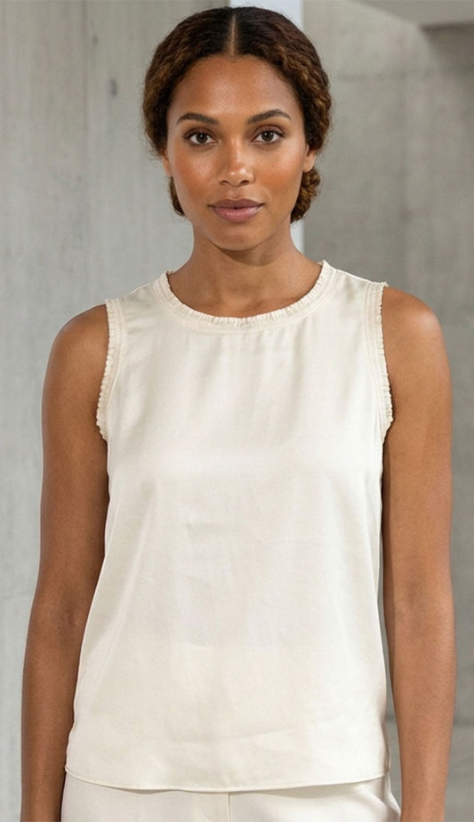 GO SILK Rouched tee in white on a woman with a cement grey background.