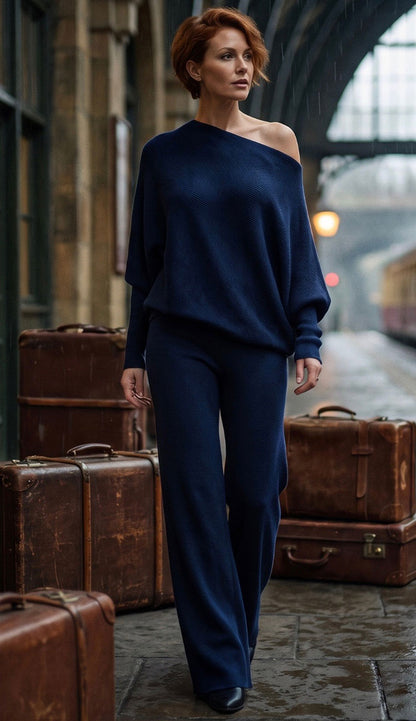 Milo Milano Navy Asymmetrical outfit on a model with vintage luggage  behind her on a street
