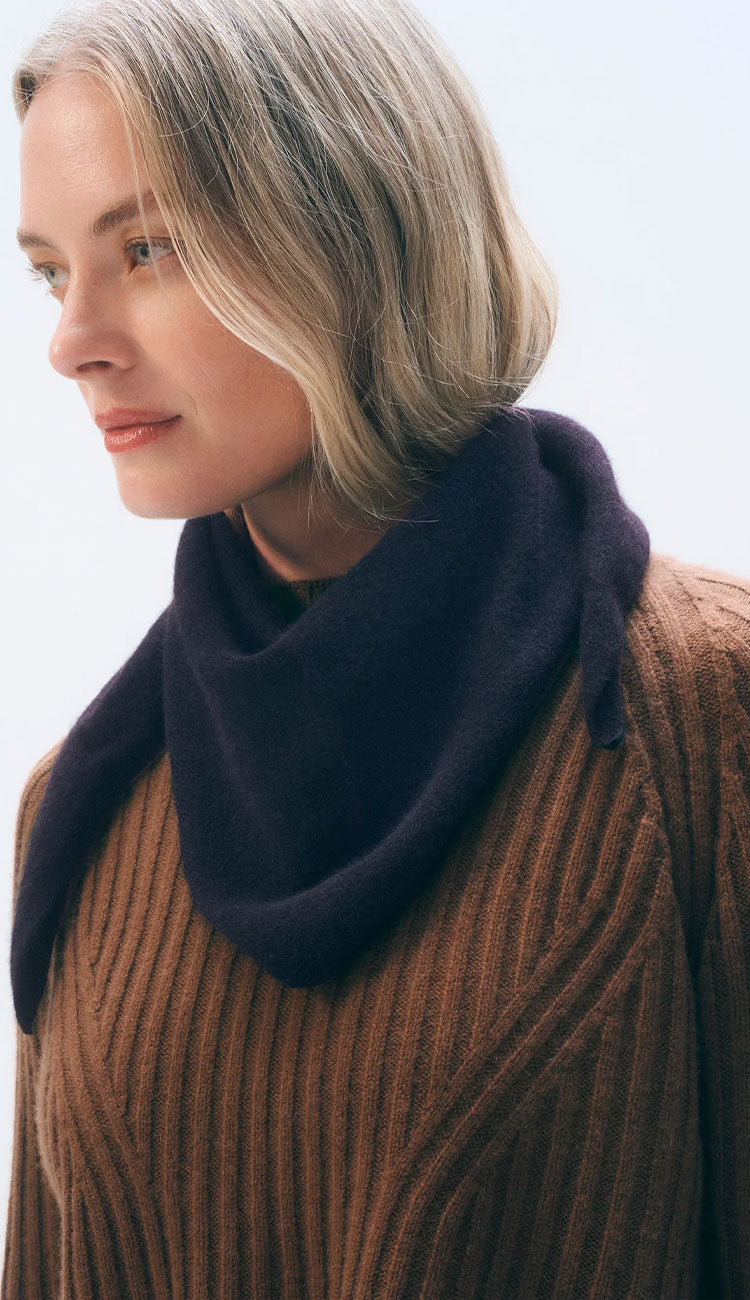 Woman wearing a white and warren cashmere neckerchief mini scarf in black on a white background