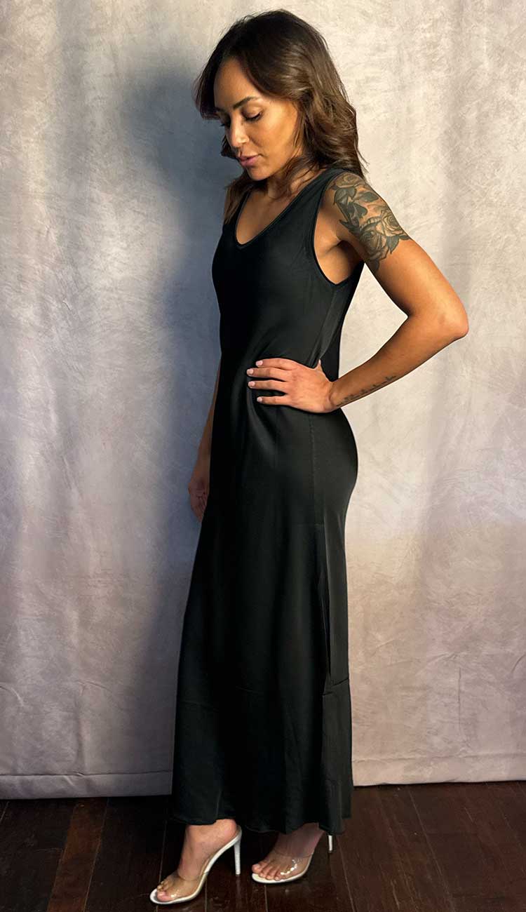 Woman wearing a black dress against a plain background
