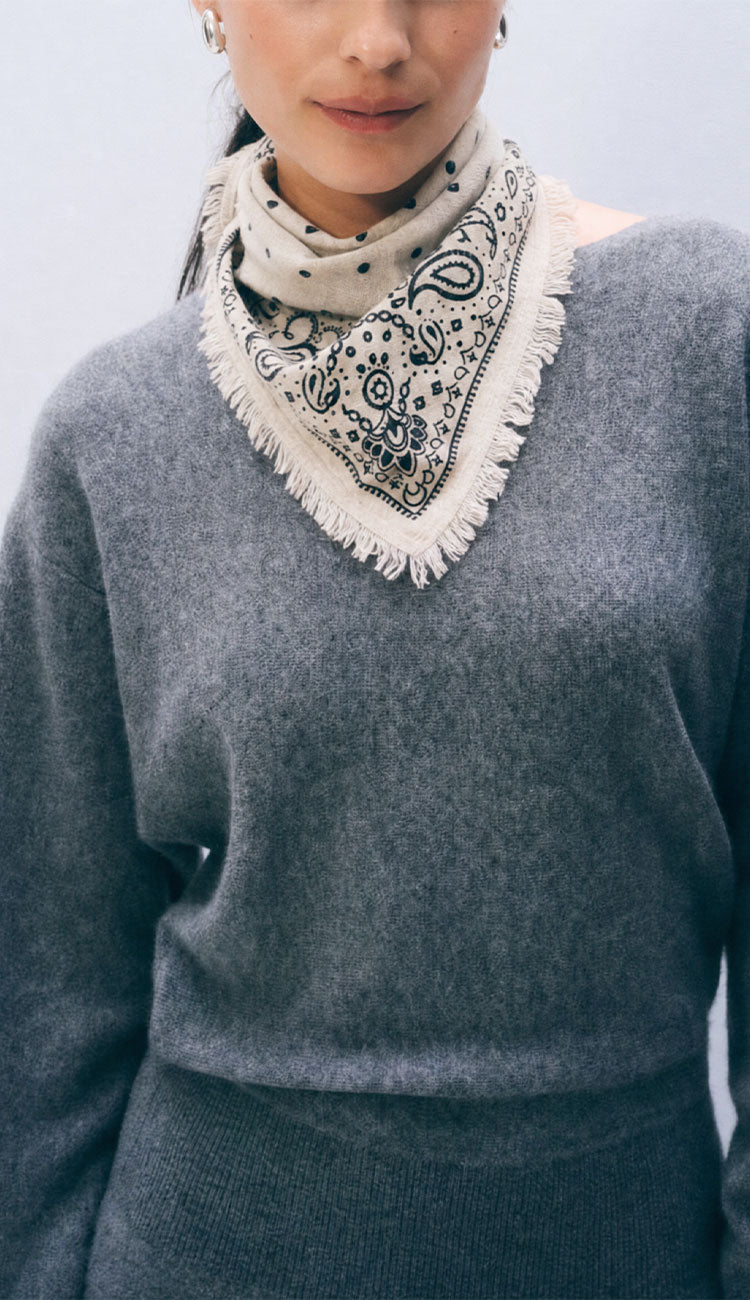 Woman wearing a White and Warren soft white bandana with a heather grey sweater on a white background.