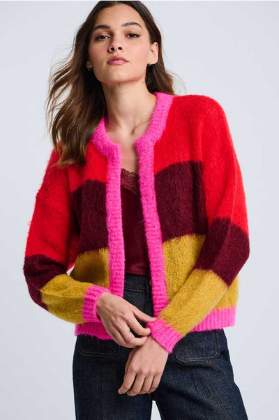 Tutti colori color blocked sweater in bright red, deep red, yellow trimmed with hot pink in an open cardi on a female with a grey background.