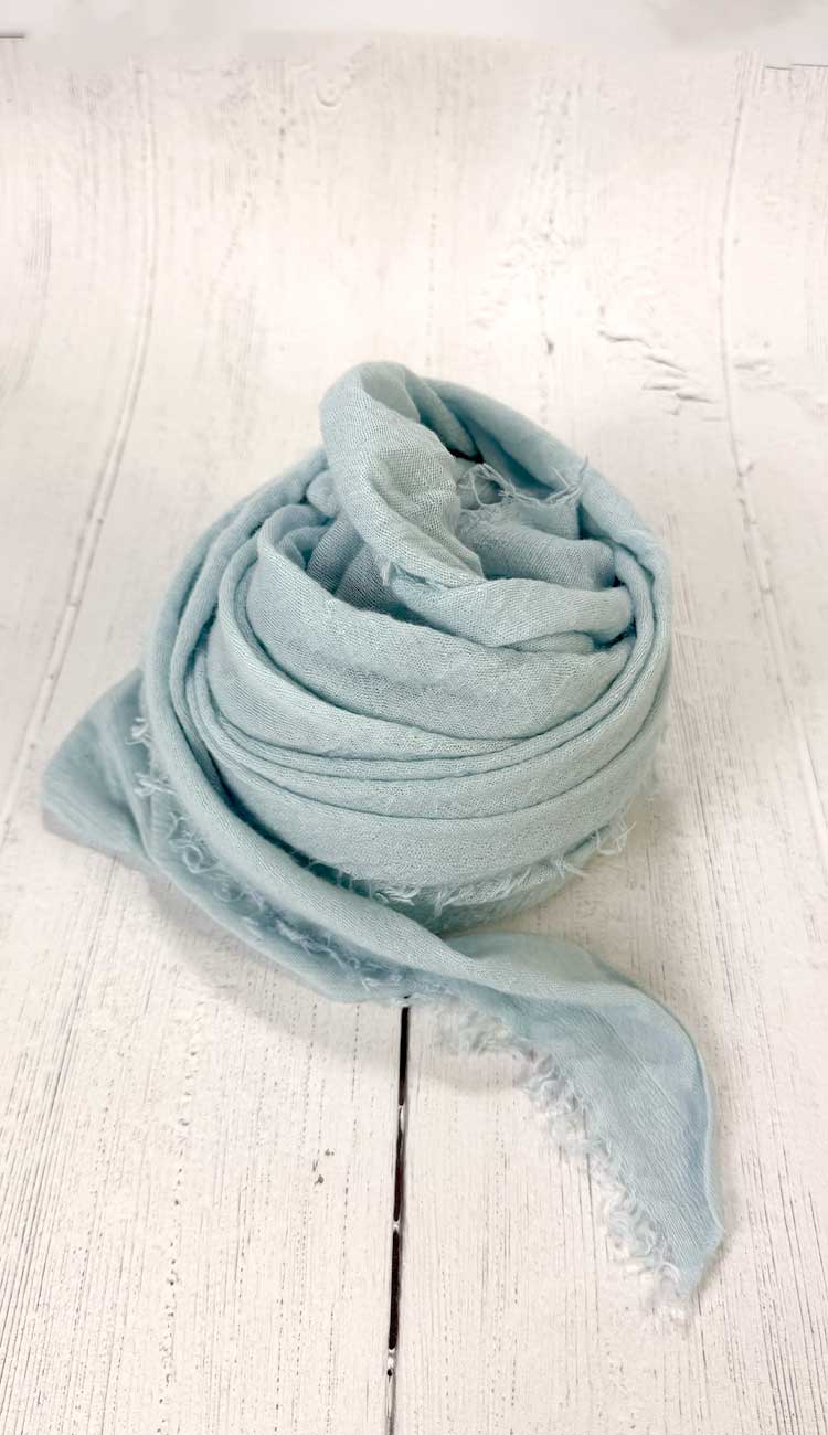 Light blue scarf on a white wooden surface