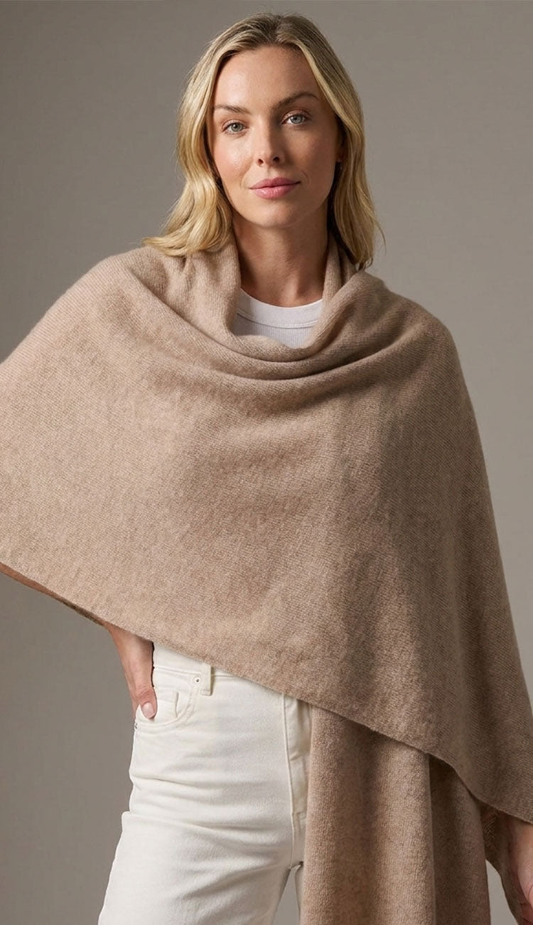 woman wearing an Alashan breezy travel wrap in natural color with a white tee and white jeans.