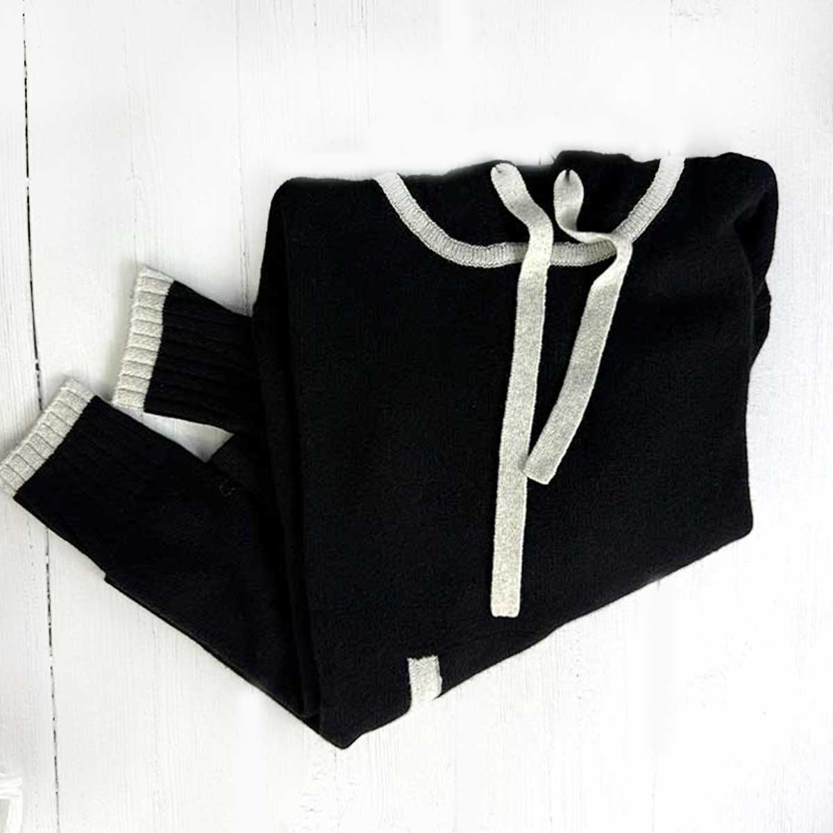 black cashmere hoodie trimmed in light grey on a white background
