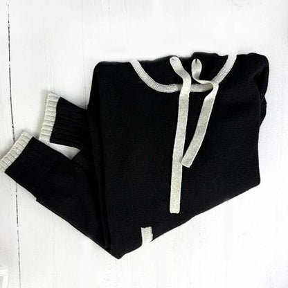 black cashmere hoodie trimmed in light grey on a white background
