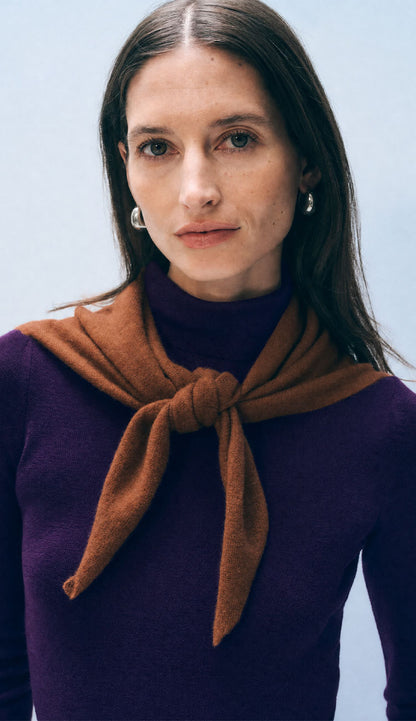 Woman wearing a white and warren cashmere neckerchief mini scarf in rusty brown on a white background