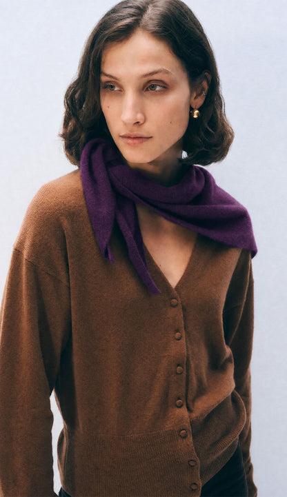 Woman wearing a white and warren cashmere neckerchief mini scarf in a dark purple color on a white background