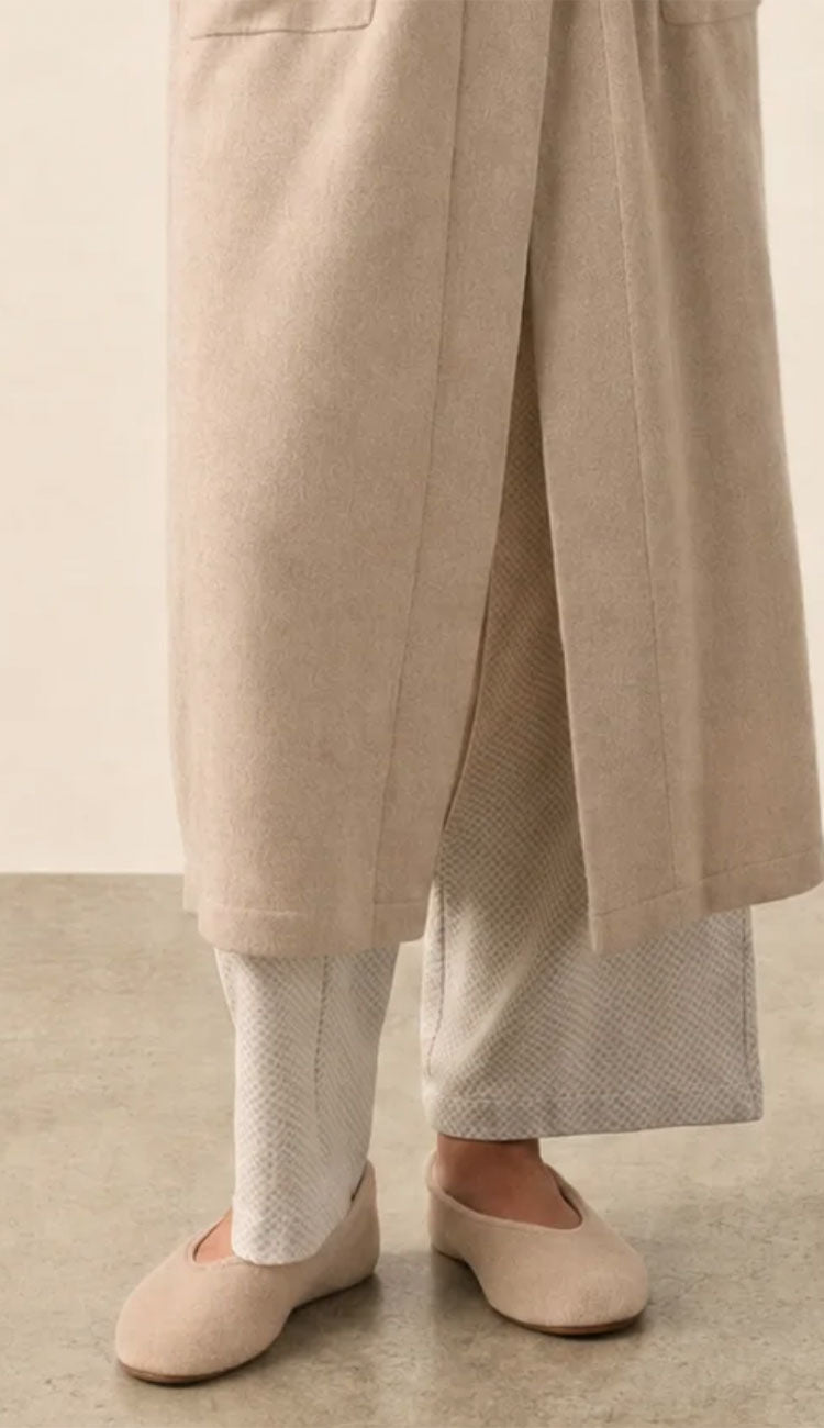 white and warren cashmere slippers in taupe heather on a model wearing pjs and a cashmere robe