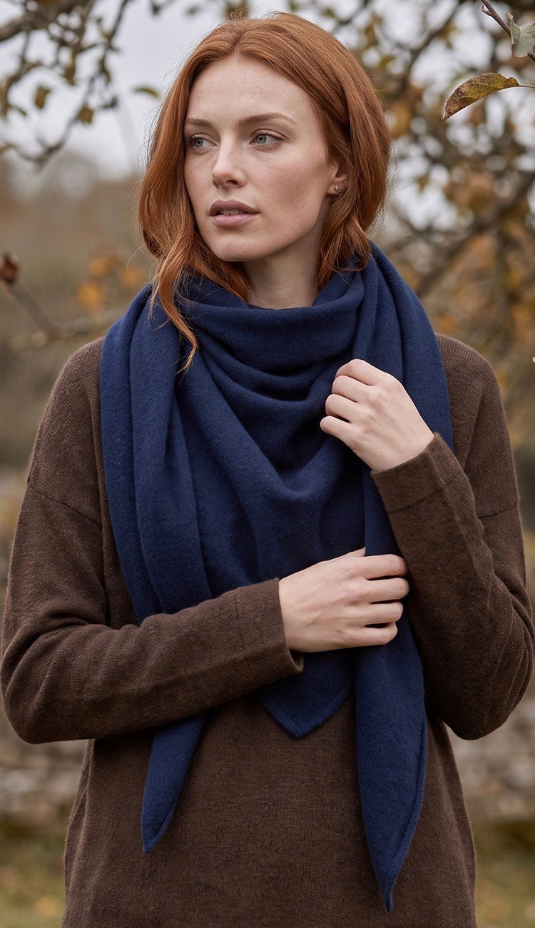 woman wearing a white and warren cashmere triangle scarf wrap with a brown sweater.