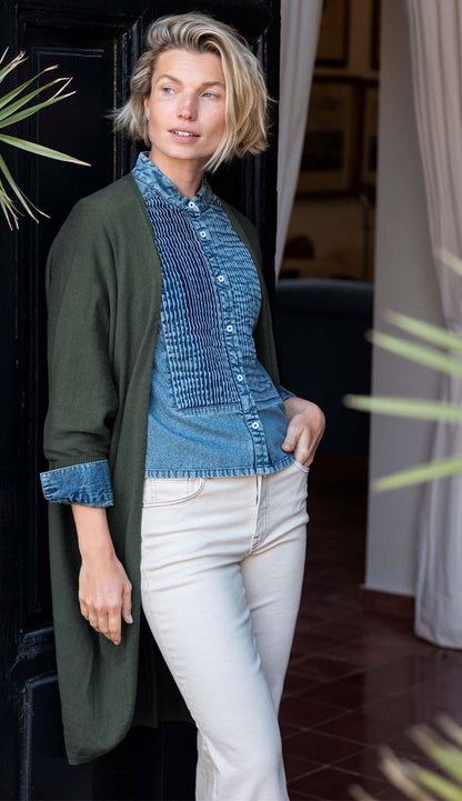 a woman wearing the Mersea chelsea kimono olive green wearing blue jean shirt and cream pants
