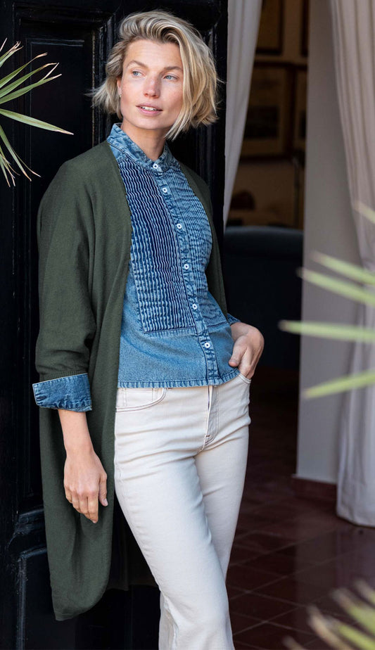 a woman wearing the Mersea chelsea kimono olive green wearing blue jean shirt and cream pants
