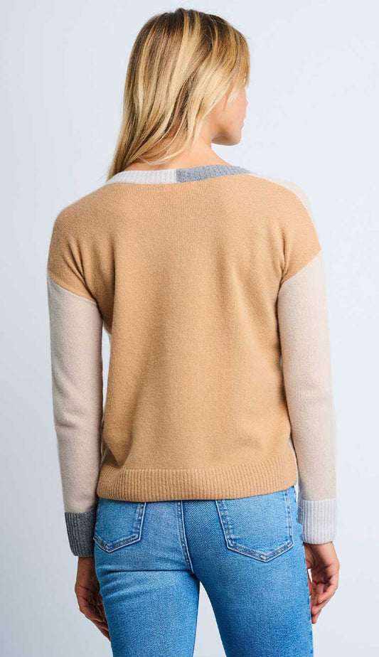 Woman wearing the color wheel sweater - back view with a beige caramel back panel and with color-blocked sleeves on a light gray background