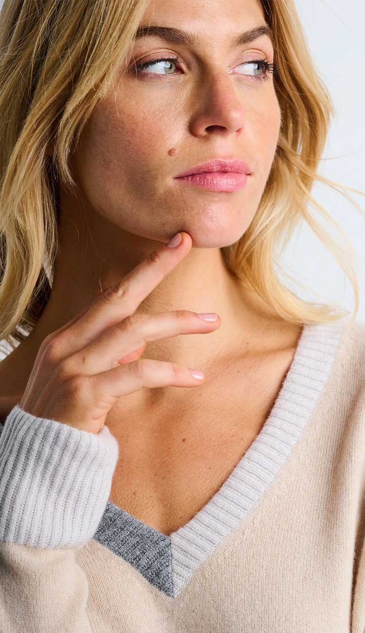 Woman wearing the color wheel sweater detail front view of neckline and sleeve with a neutral background