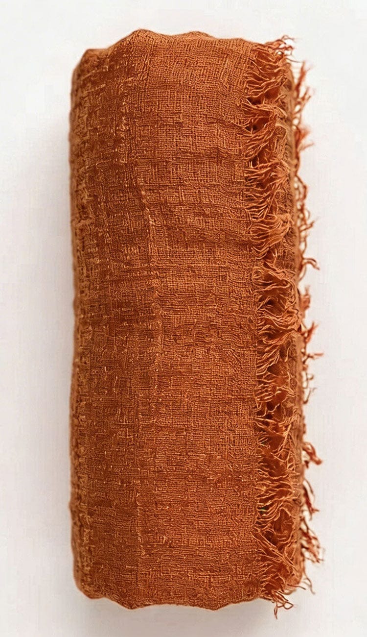 copper textured fabric with frayed edges on a white background