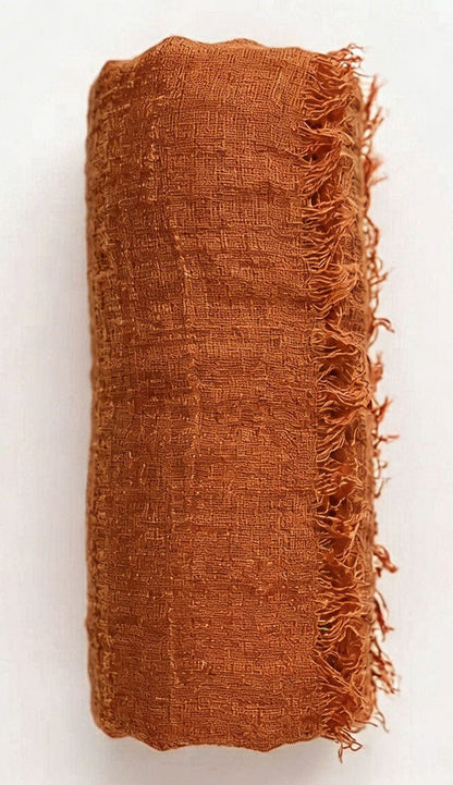 copper textured fabric with frayed edges on a white background