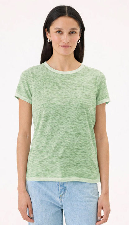 Goldie Tee in Sunwash palm green on a woman wearing blue jeans with a white background.