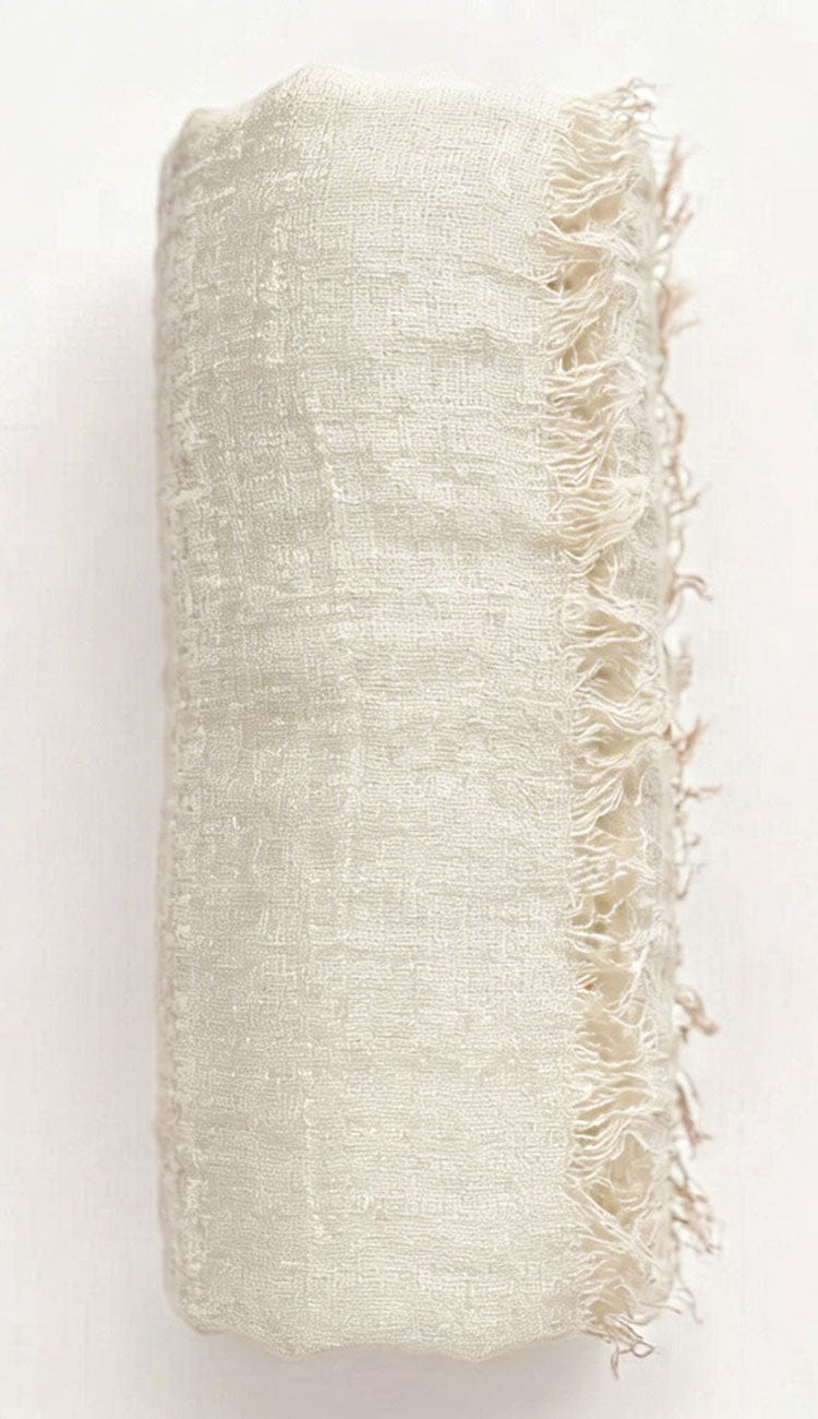 Textured beige fabric with frayed edges on a white background