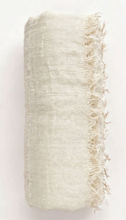 Textured beige fabric with frayed edges on a white background