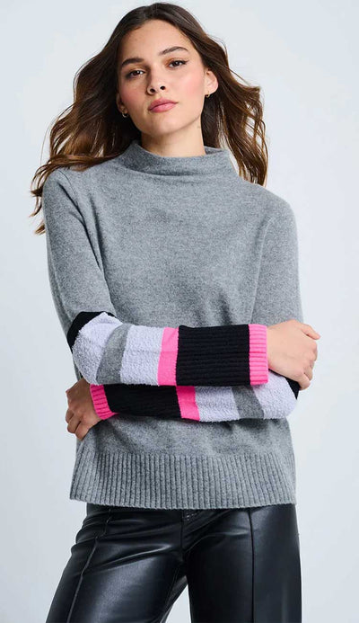 Woman wearing a gray sweater with colorful sleeves on a light gray background