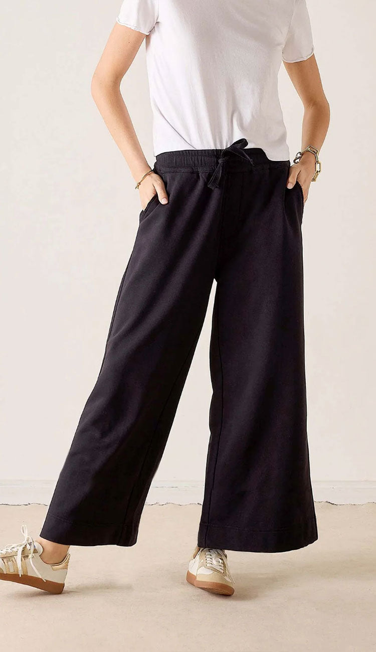 woman wearing a white tee and Mersea Frenchie WIDE Leg pants in black with sneakers