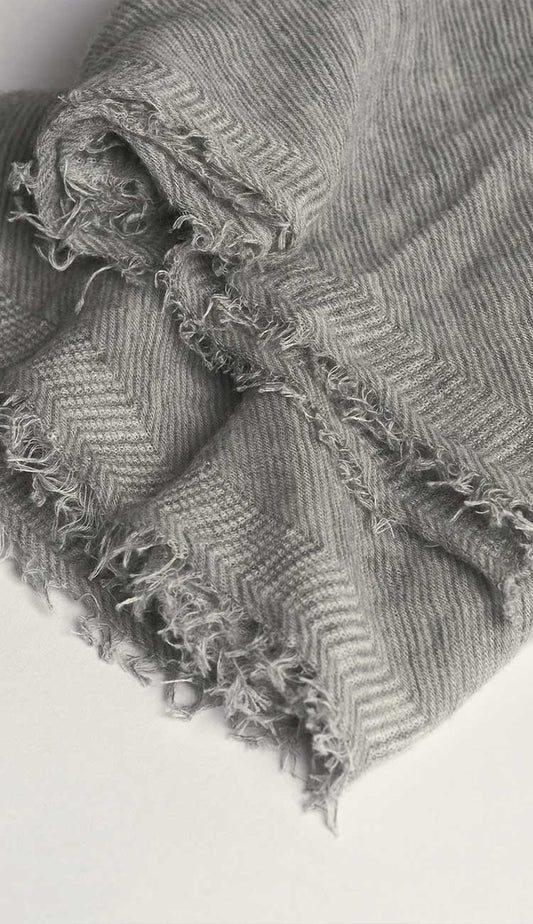 Gray and cream microstripe textured fabric with frayed edges on a white background