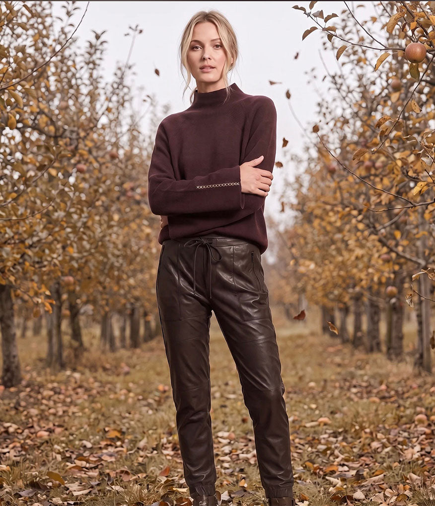 Woman wearing a brown Lisa Todd cashmere sweater with dark brown Raffaello Rossi Candy faux-leather in an autumn background of trees
