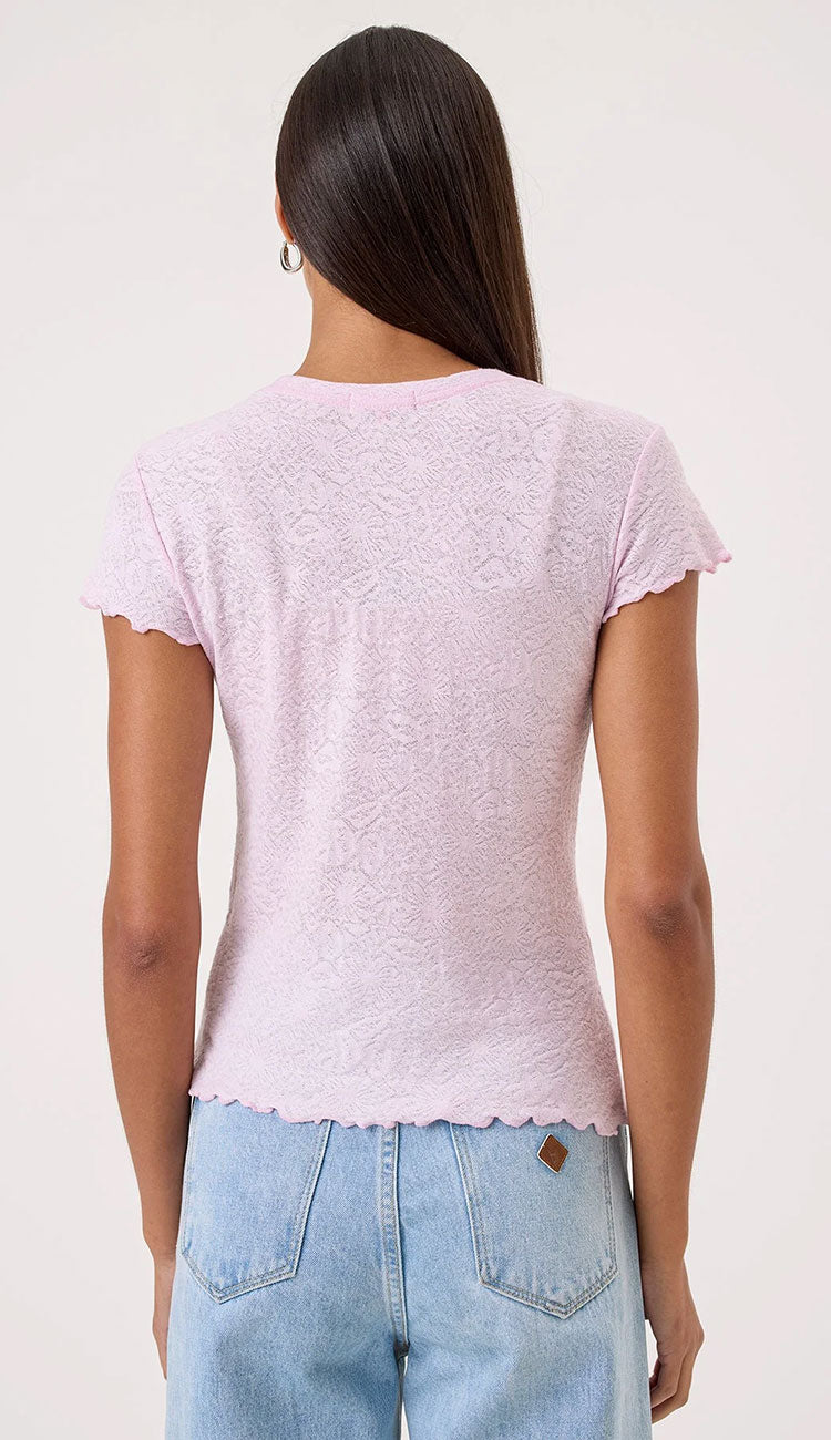 Woman wearing a Goldie Love Story light pink top and blue jeans on a white background - back view
