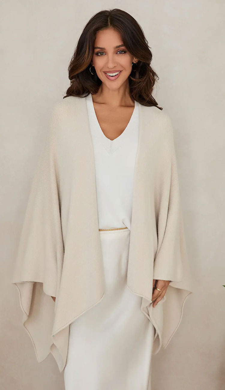 Woman wearing the milio milano knit dolman sleeve open cardigan wrap with classic ivory 