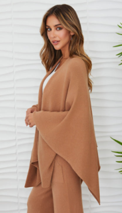 Woman wearing the milio milano knit dolman sleeve open cardigan wrap with camel flaire pants and a white tee - side view
