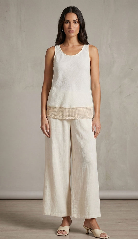 Woman wearing a butter light  light yellow sleeveless top and matching wide-leg pants against a neutral background