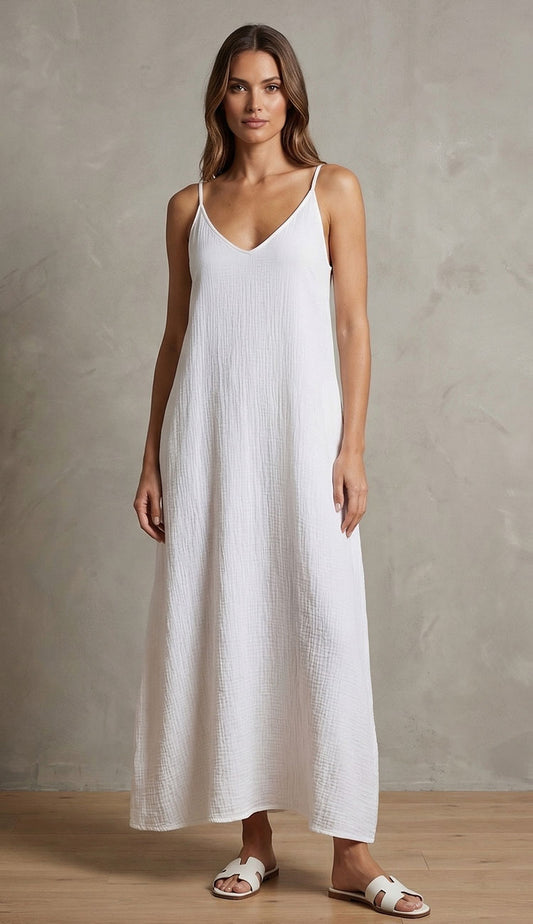 Woman wearing a milio milano white linen dress against a neutral background