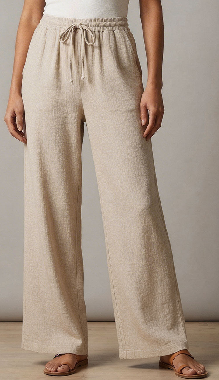milio milano linen pants with a white tee a against a neutral background.