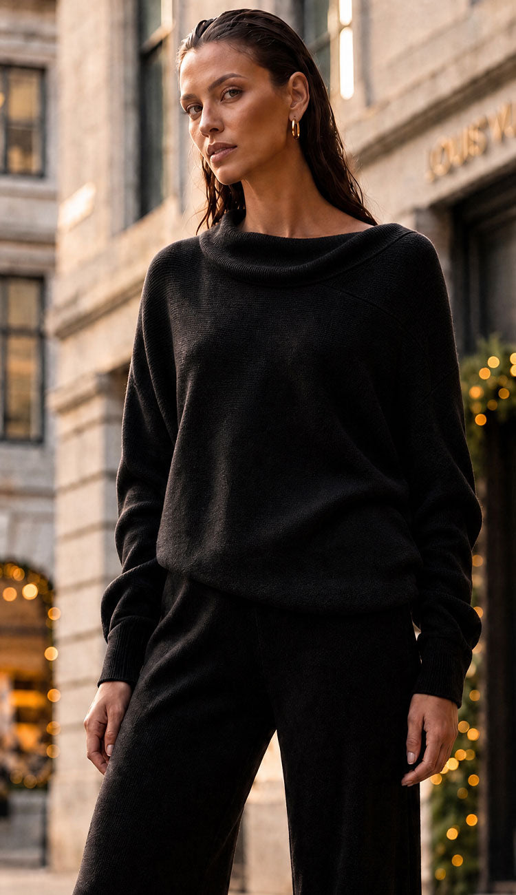 milo milano asymmetrical top worn as a mock-neck paired with the flair pants