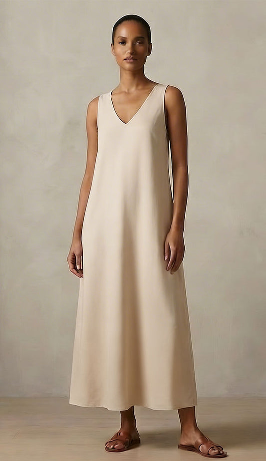 Woman wearing a Milio Milano beige sleeveless dress against a plain background