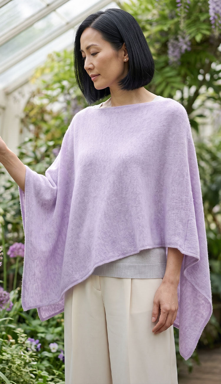 A woman wearing the Mystical light lavender knit topper poncho sweater.