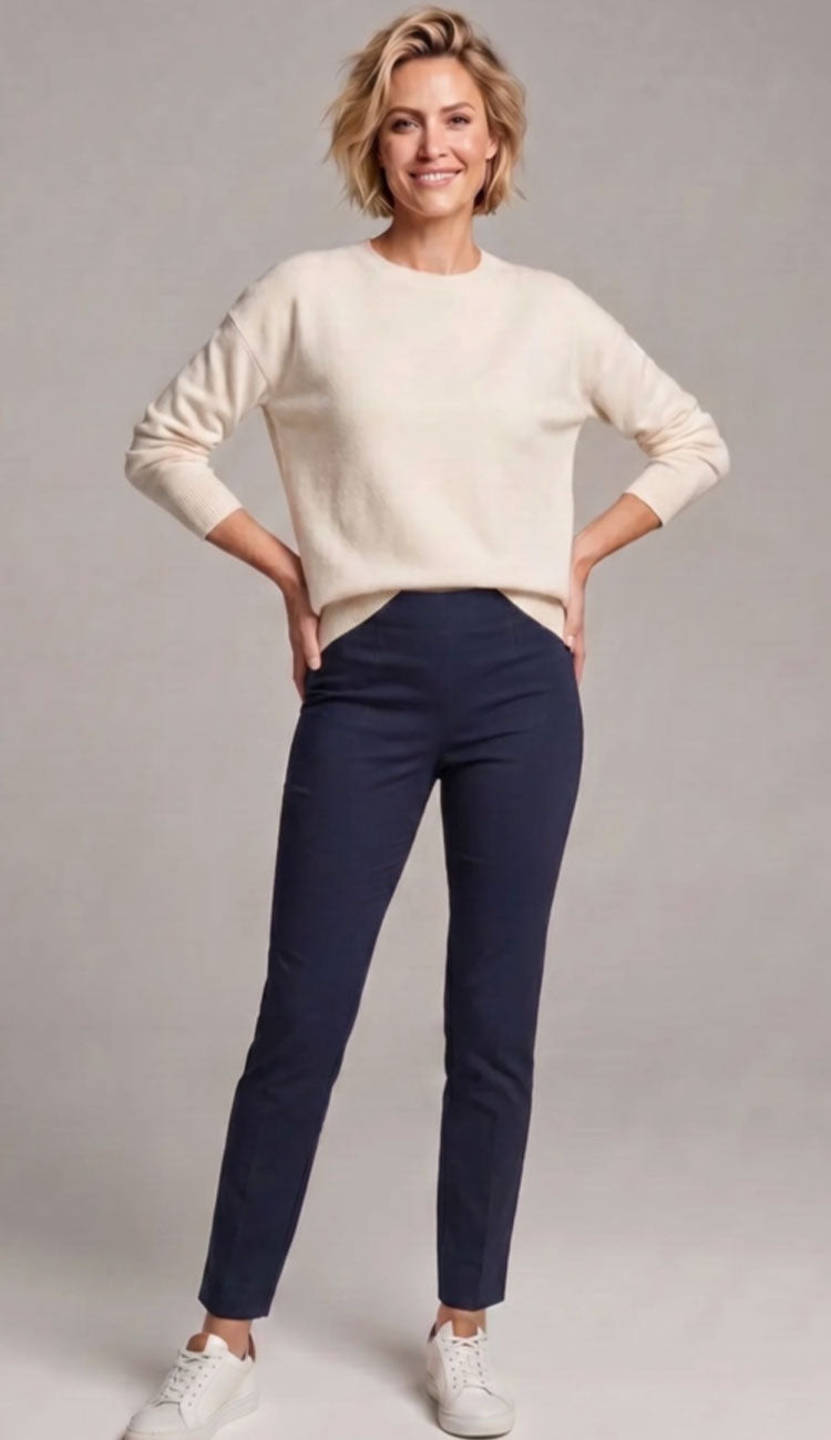 Woman wearing a navy pair of white RAFFAELLO ROSSI penny pants with cream top against a grey background