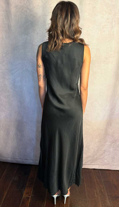 Person wearing a black sleeveless dress against a plain background - back view