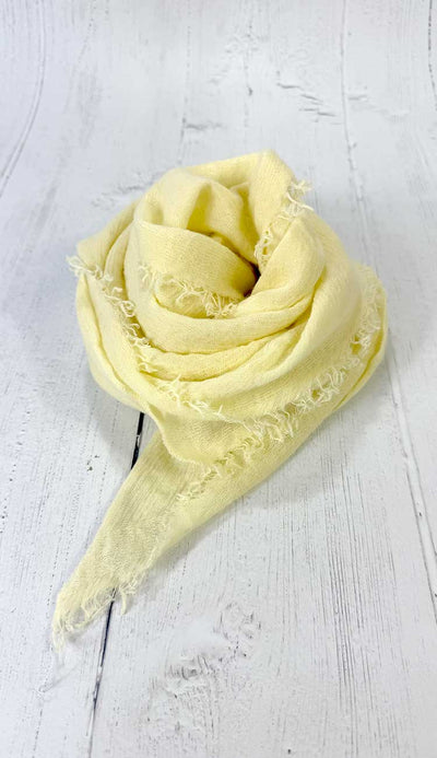 Yellow scarf  on a white wooden surface
